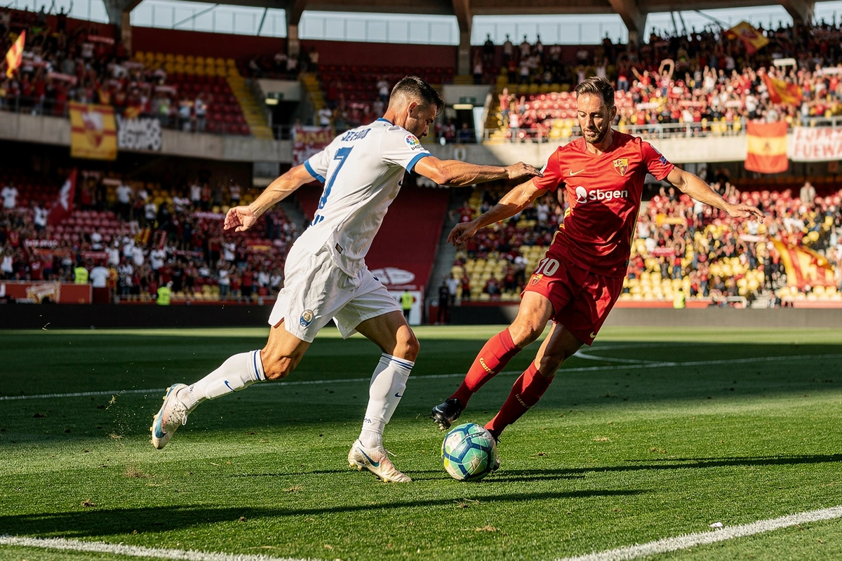 Acci&oacute;n de partido en estadio espa&ntilde;ol con jugadores disputando el bal&oacute;n