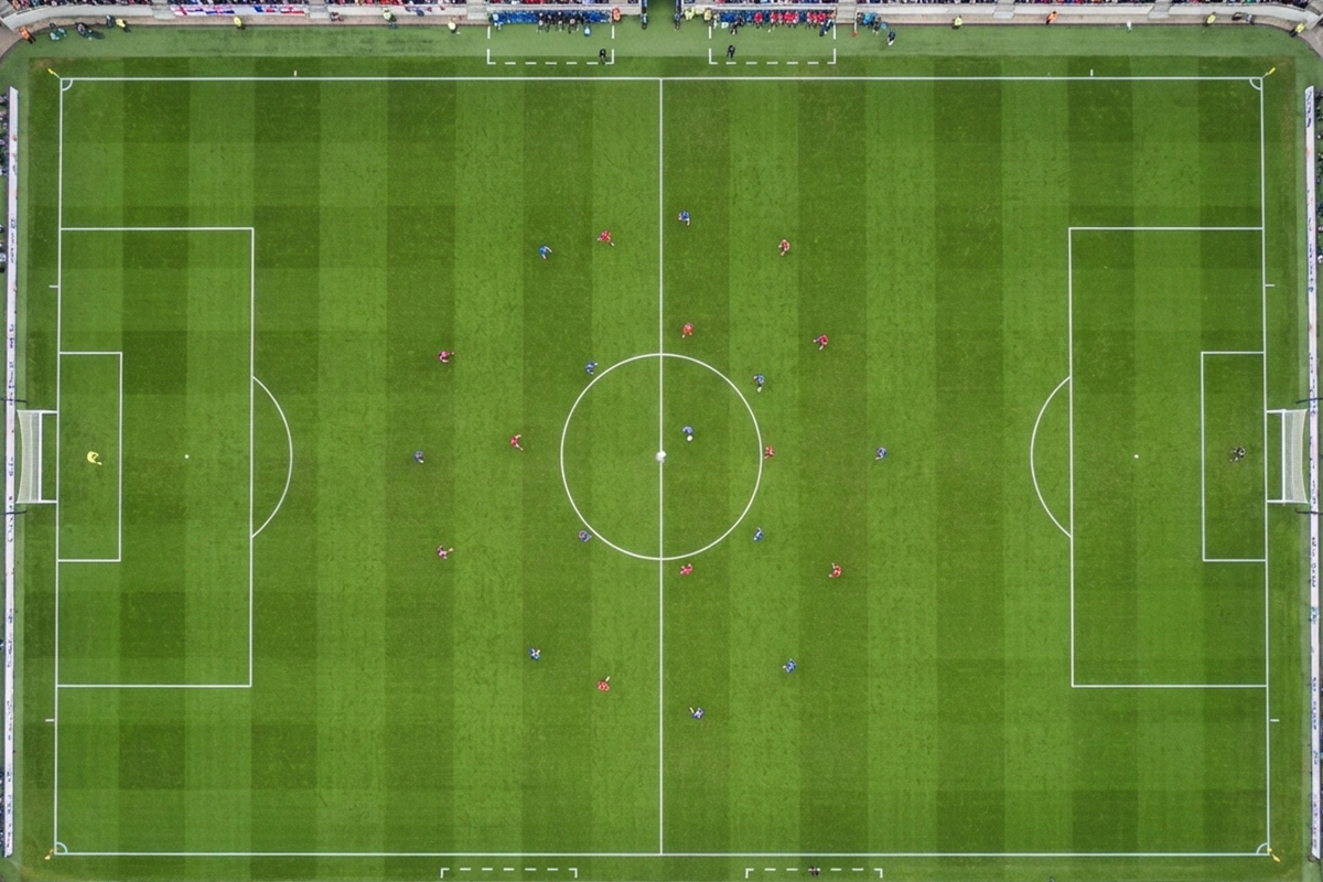 Vista a&eacute;rea de campo de f&uacute;tbol durante partido con formaciones t&aacute;cticas visibles